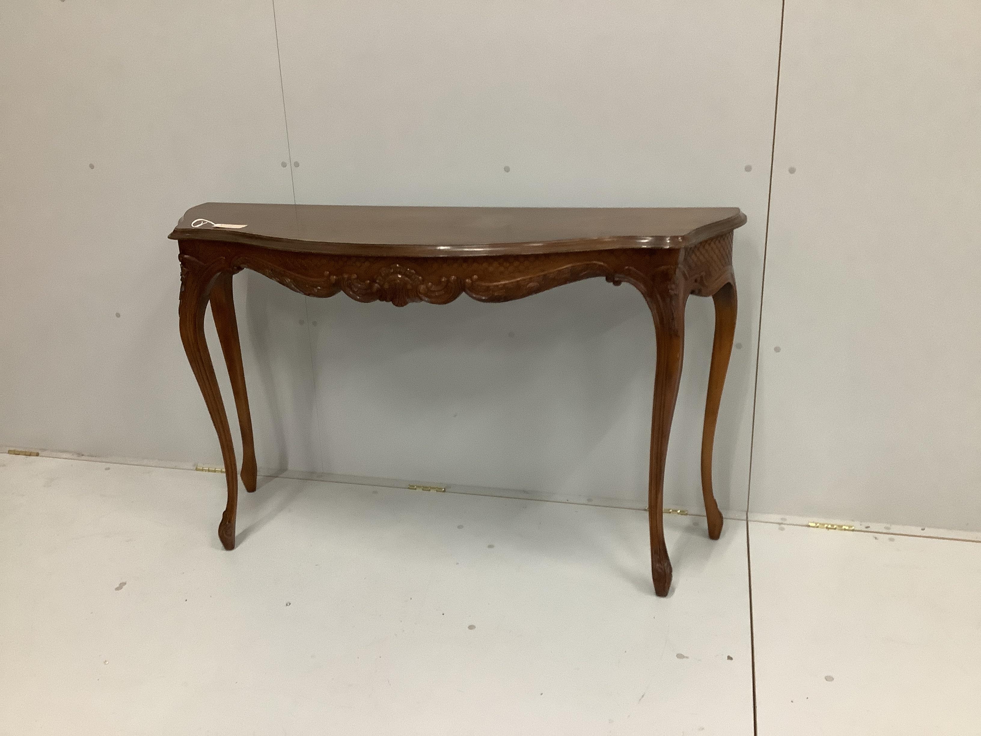 A reproduction serpentine fronted console table, with carved frieze, on cabriole legs, width 136cm, depth 45cm, height 83cm